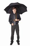 Serious man in black clothes with an umbrella