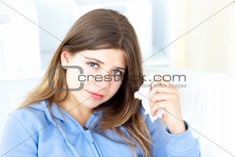 Upset young woman holding a tissue
