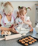 Smiling woman baking cookies with her daughters 