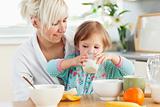 Radiant woman having breakfast with her daughter