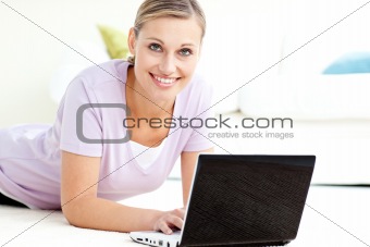 Positive woman using her laptop on the floor 
