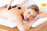 Smiling caucasian woman receiving a massage with hot stone