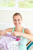 Cheerful young woman doing the laundry 