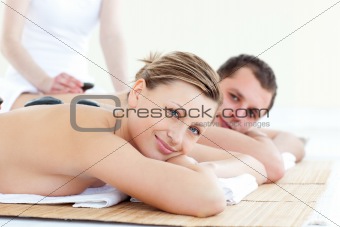 Smiling young couple having a stone massage