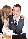 Beautiful blond businesswoman giving her smiling boyfriend a kis