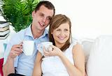 Portrait of a loving young couple drinking coffee at home