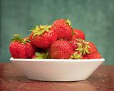 Ripe berries of strawberry in plate on table