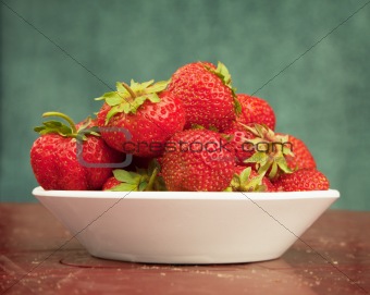 Ripe berries of strawberry in plate on table