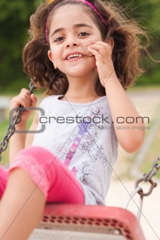 Lovely girl on a swing in the park