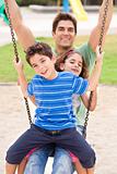 Father and children enjoying swing ride