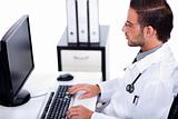 male doctor working with desktop at his desk