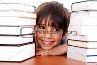 Young kid relaxing between pile of books