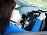 Brunette young woman using her cellphone while driving