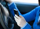 Close-up of a teenager sending a text while driving 
