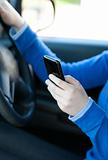 Close-up of a caucasian young woman sending a text while driving