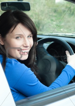 Glowing female teenager sitting in her new car 