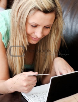 Portrait of a beautiful woman holding a card using her laptop