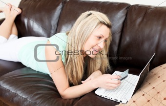 Radiant young woman using her laptop on the sofa