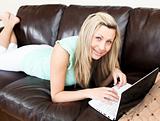 Positive caucasian woman using her laptop on the sofa 