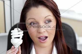Surprised businesswoman holding a light bulb 
