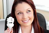 Delighted businesswoman holding a light bulb 