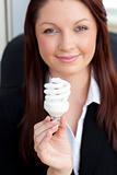 Charismatic businesswoman holding a light bulb 