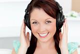 Happy young woman listen to music looking at the camera 