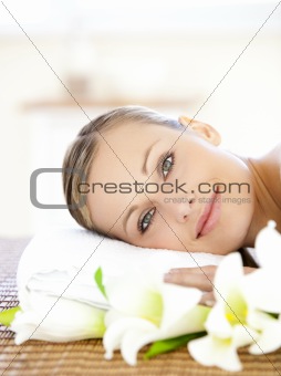 Pretty woman lying on a massage table looking at the camera 