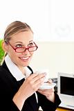 Beautiful businesswoman holding coffee working at office with a laptop