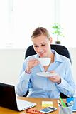 Glad young businesswoman drinking coffee 