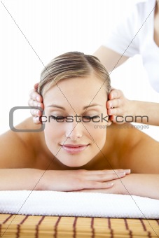 Radiant young woman receiving a head massage 