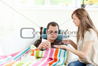 Caring girlfriend giving his sick boyfriend pill