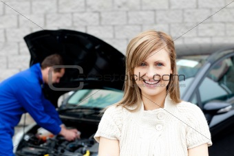 Man repairing car of smiling woman