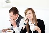 Charming businesswoman drinking coffee while her husband eating 
