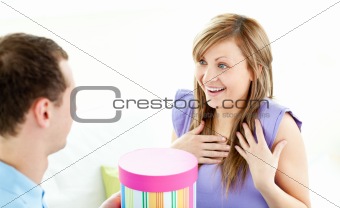 Attentive man giving a present to his girlfriend at home