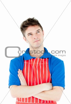 Serious young cook wearing a apron with folded arms 
