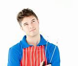 Thougtful young cook holding a cookware 