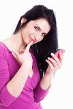 beautiful young woman on the phone, smiling at the camera with one finger to touch the mouth