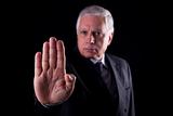 old businessman  with his hand raised in signal to stop