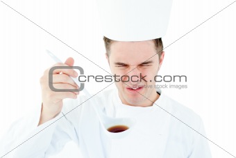 Young male chef tasting a soup with distorted face