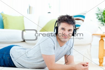 Handsome man with headphones lying on the floor