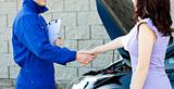 Caucasian young mechanic shaking hands with a female customer