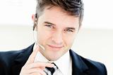 Charming young businessman with headphones smiling at the camera