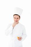 Smiling male chef eating fresh bread looking at the camera 