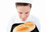 Handsome male cook smell at a fresh bread 