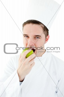 Enthusiastic male cook eating a green apple 