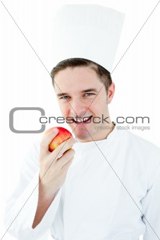 Happy male cook holding  red apple smiling at the camera