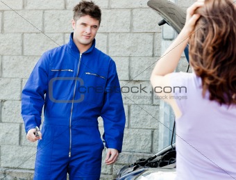 Handsome mechanic at the garage with a desperate woman