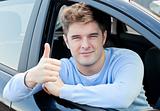 Attractive young man sitting in his car with thumb up