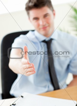 Self-assured businessman reaching his hand to the camera 